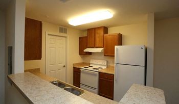 A kitchen with a white refrigerator, white stove, and white countertop.